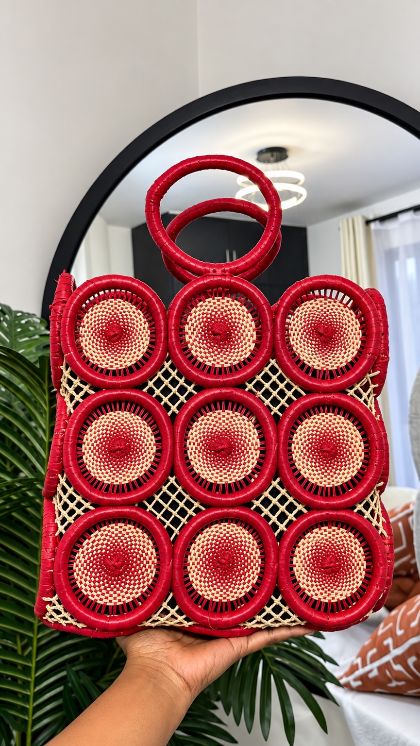 KIKARA PENDO handwoven red bag held in the light